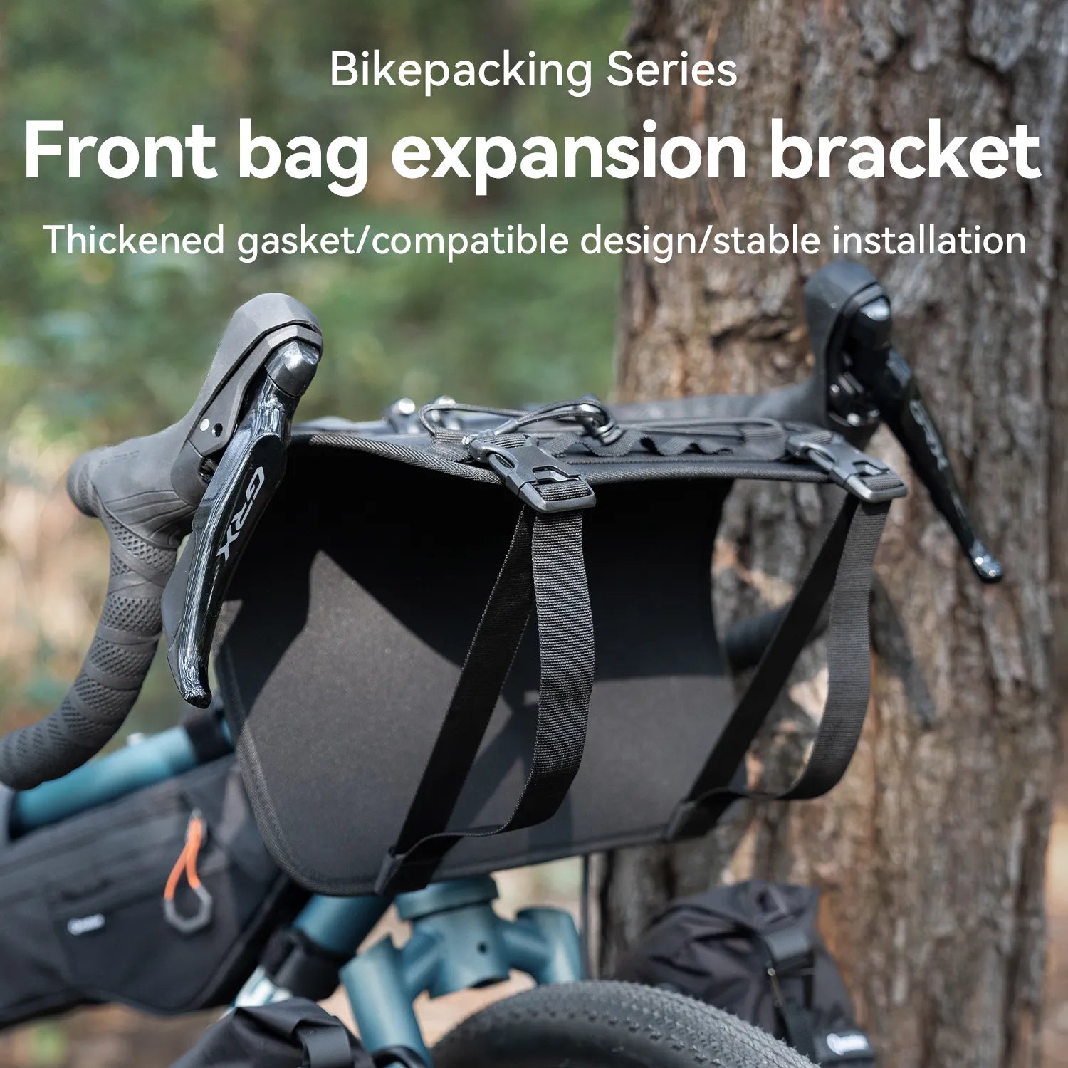 A bicycle with a black adjustable handlebar cradle bike bag carrier outdoors next to a tree